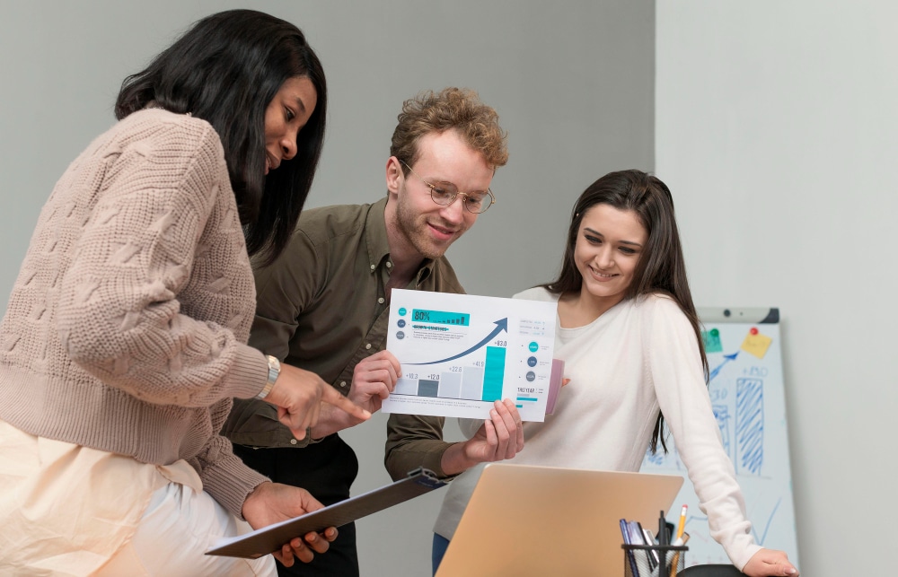 Team reviewing performance charts together, discussing ways to improve employee performance.
