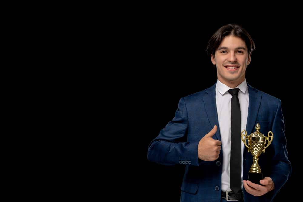 A person holding a trophy, symbolizing recognition and reward for outstanding performance.
