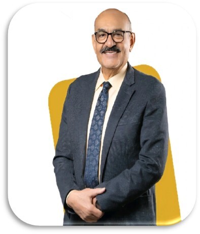 Studio portrait of a smiling executive with glasses and a mustache, wearing a dark textured blazer, light button-down shirt, and patterned tie, set against a white background with a gold geometric shape.
